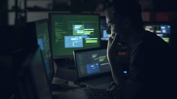 Computer developer working with computers at night